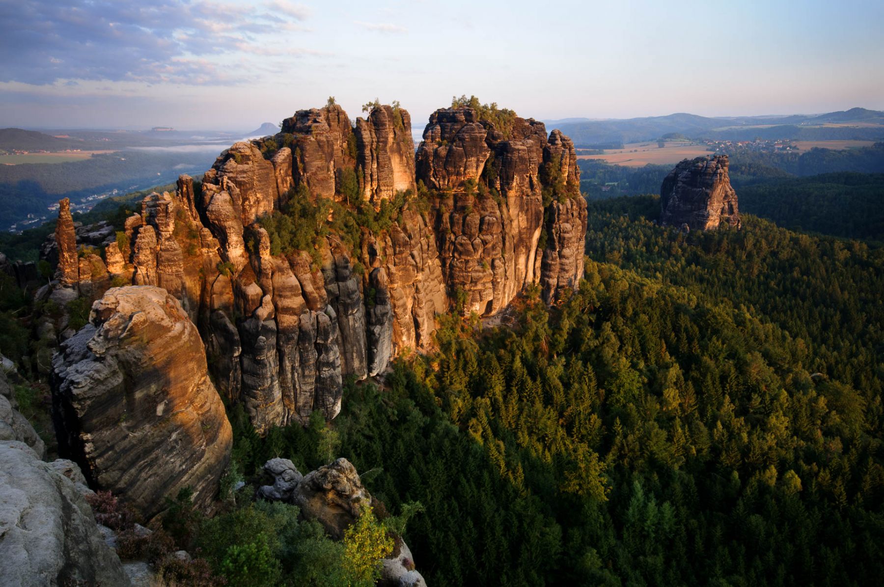 Imposante Sandsteinfelsen der Schrammsteine im Elbsandsteingebirge bei Sonnenaufgang.